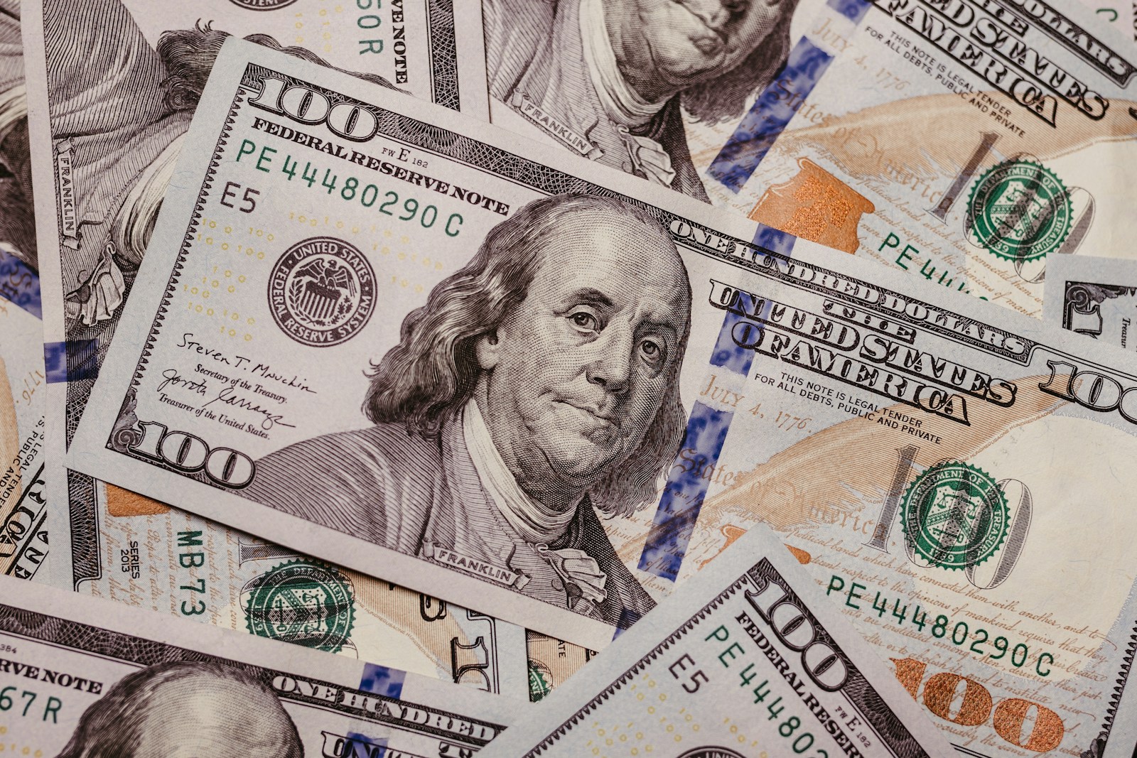 a pile of one hundred dollar bills